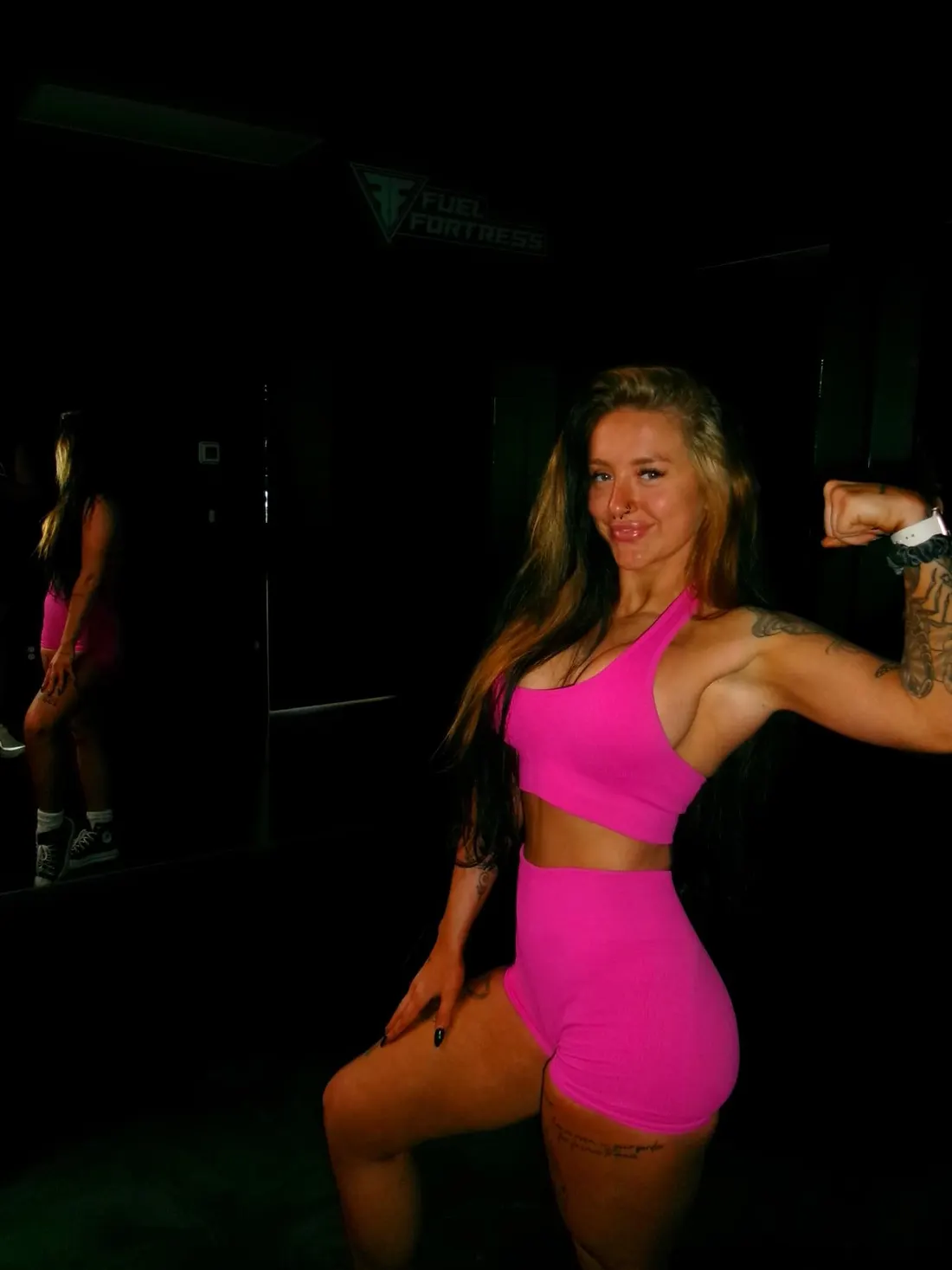 Shannon Strand flexing in a pink set at Fuel Fortress Nashville